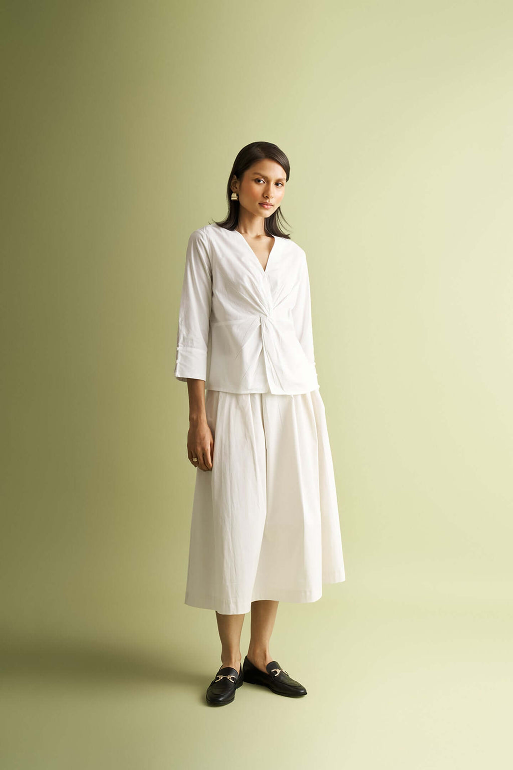 White front twist top, by Nicobar, styled with a midi skirt and black loafers.
