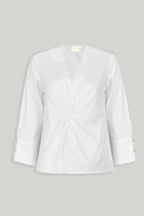 White blouse with front twist by reistor with three quarter sleeves and buttoned cuffs.