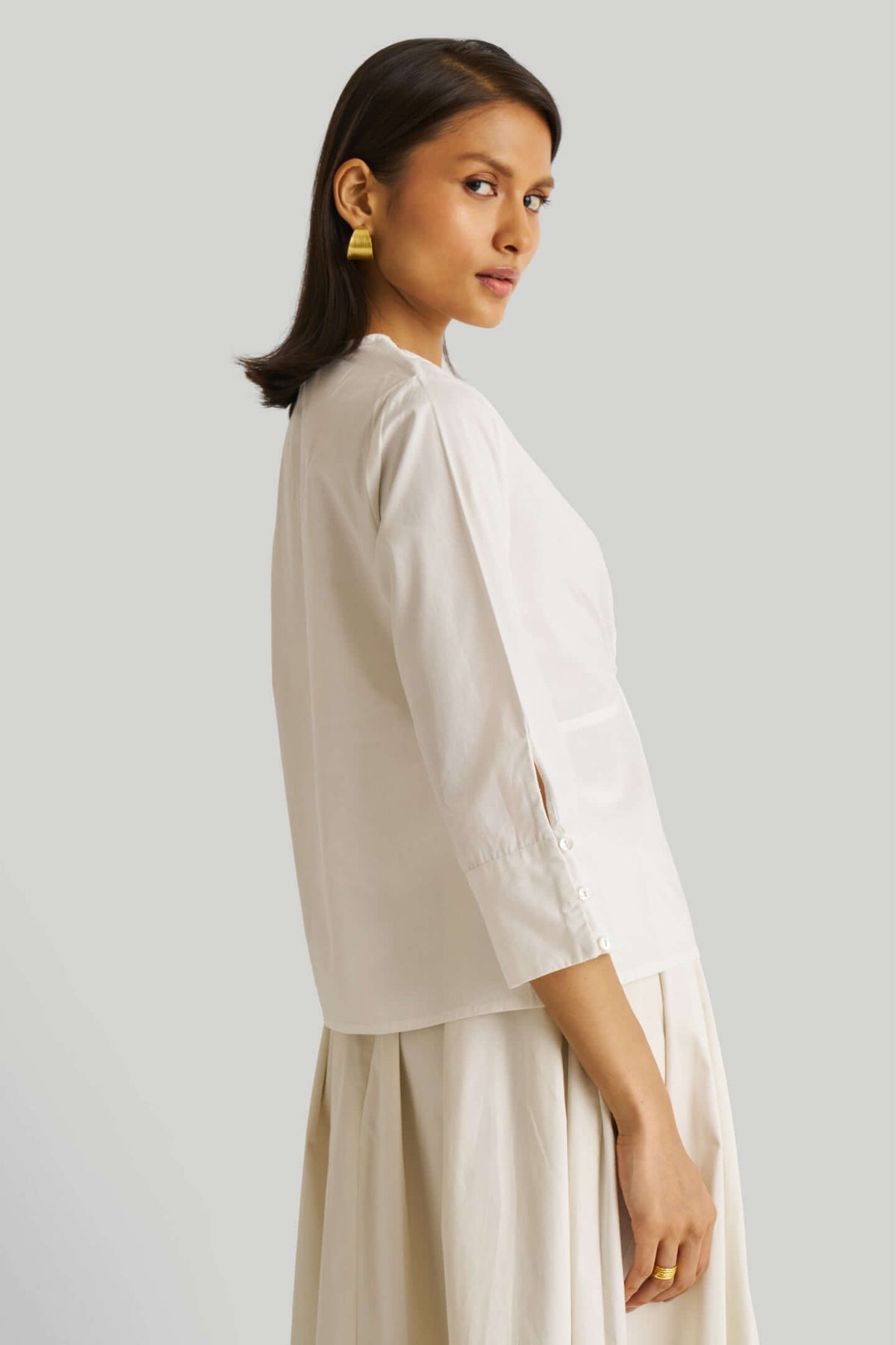 White front twist top by Nicobar with three-quarter sleeves and a midi skirt.