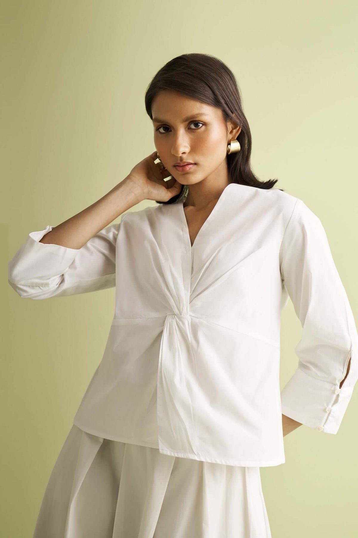 White front twist top by a nameless vendor, with long sleeves and cuff button detail.